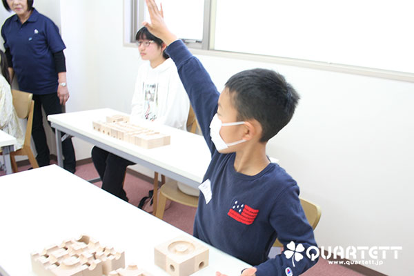 小学生の男の子が元気よく手を挙げている
