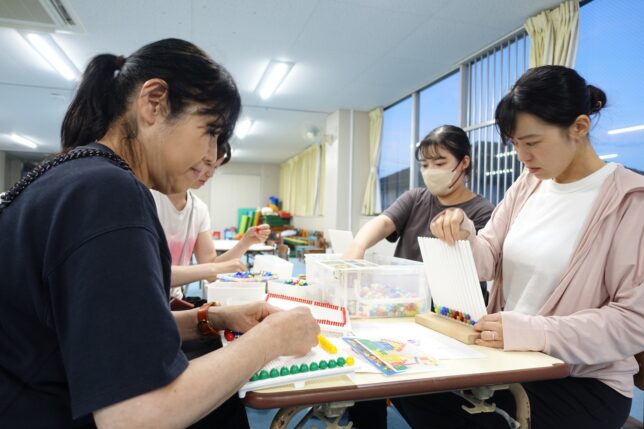保育士研修 構成遊び ペグボードに色を並べる先生の手元