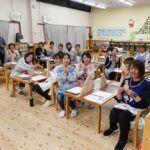 保育士向け積木研修で参加者全員が笑顔で記念撮影している様子