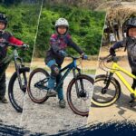 エイトショットのマウンテンバイクにまたがる大野三兄弟。ヘルメットを着用し、屋外で笑顔で撮影。