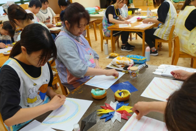 保育環境改善プログラム 造形研修 画用紙に向かって描く先生方の制作活動の様子