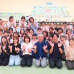 日本知育玩具協会の保育士向け研修に参加した講師と保育士たちの集合写真。研修室で全員が笑顔で両手を上げ、和やかな雰囲気で記念撮影